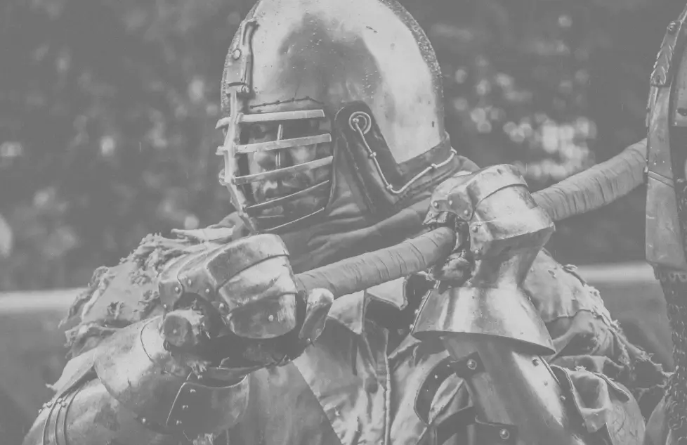 A black and white photo of a buhurt fighter in armor.